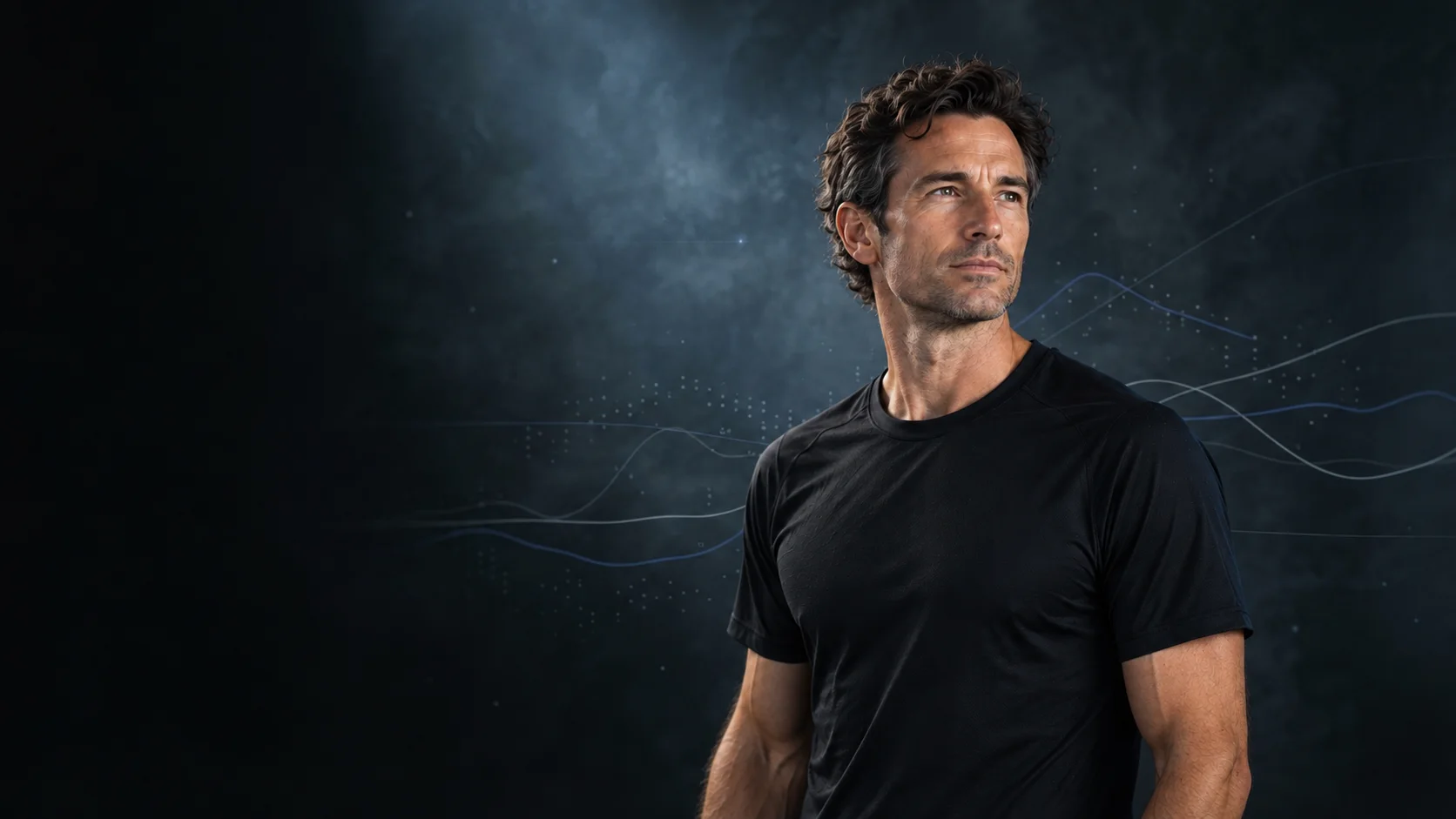 An endurance athlete in dark training kit, lit softly against a dark blue-grey backdrop.